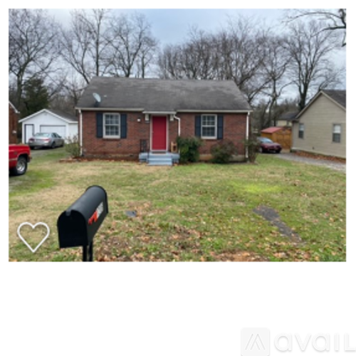 A brick house with a red door and mailbox in front.