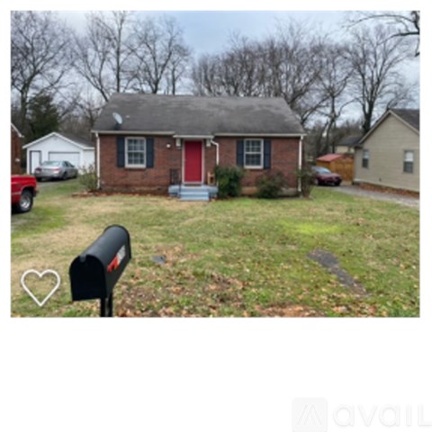 A brick house with a red door and mailbox in front.
