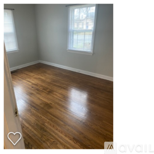 A room with wooden flooring and a window.