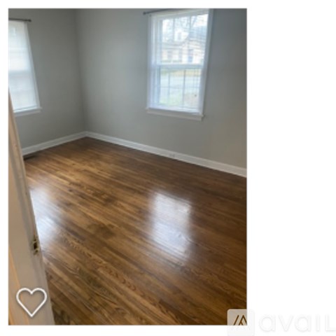 A room with wooden flooring and a window.
