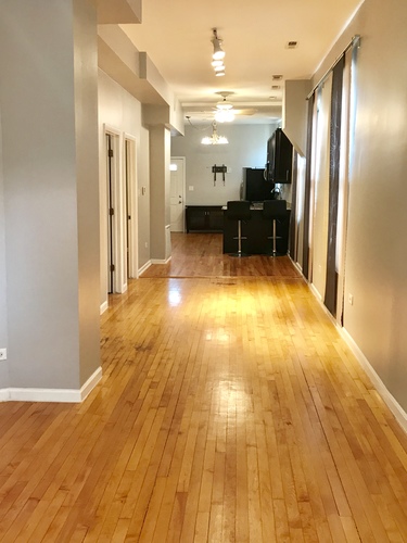 A long hallway with wooden floors and white walls.