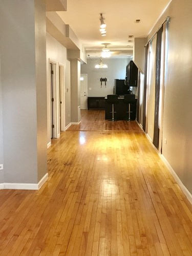 A long hallway with wooden floors and white walls.