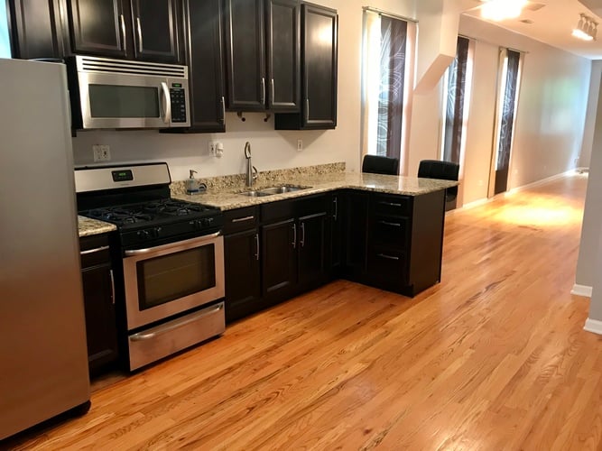 A kitchen with black cabinets and stainless steel appliances.