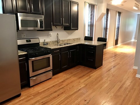 A kitchen with black cabinets and stainless steel appliances.