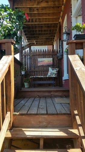 A wooden deck with a bench and a fence.