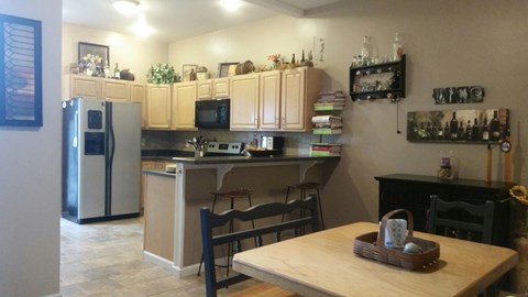 A kitchen with a refrigerator, microwave, oven, and sink.