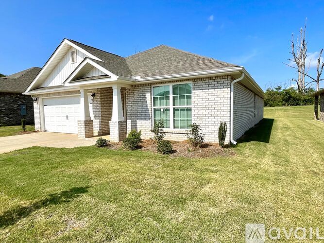 A house with a white garage door and a brick wall.