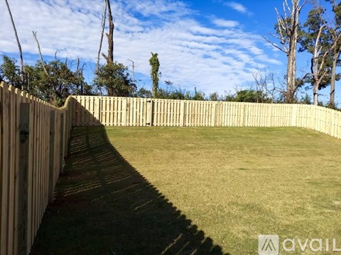 A backyard with a wooden fence and a grassy area.