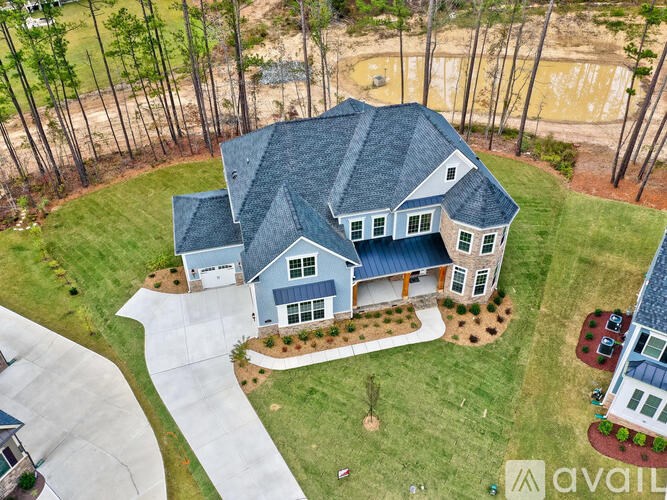 A house with a blue roof and a white garage door is for sale.