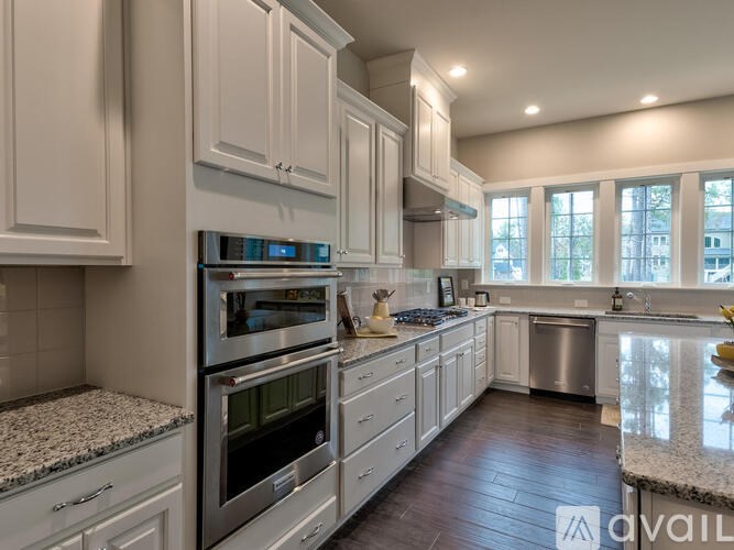 A modern kitchen with stainless steel appliances and white cabinets.