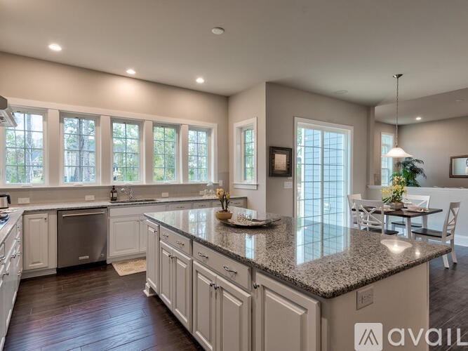 A kitchen with a granite countertop and white cabinets.