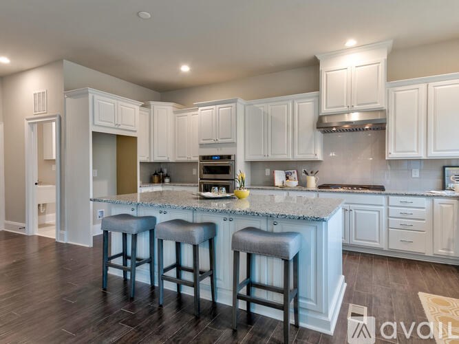 A kitchen with white cabinets and a blue island.