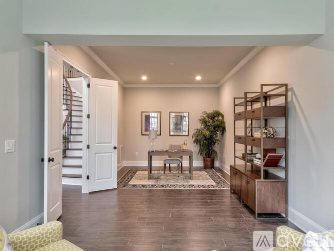 A spacious living room with a staircase and a wooden floor.