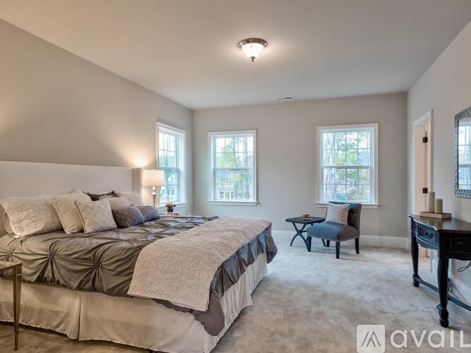 A bedroom with a large bed and a chair.