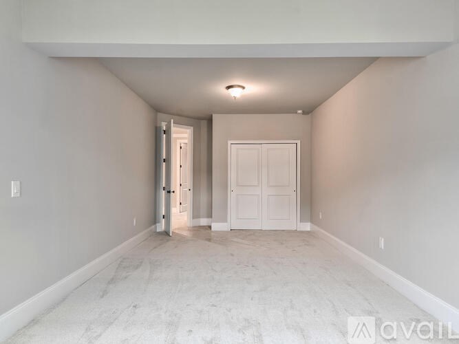 A spacious room with a door on the left and a door on the right.