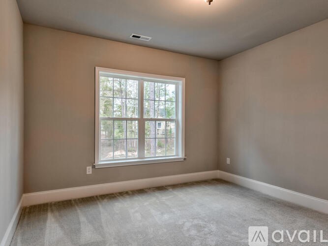 A room with a window and carpeted floor.