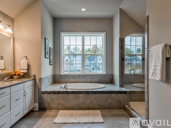 A bathroom with a large window overlooking a street.