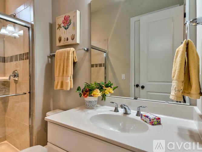 A bathroom with a white sink and a yellow towel hanging on the towel rack.