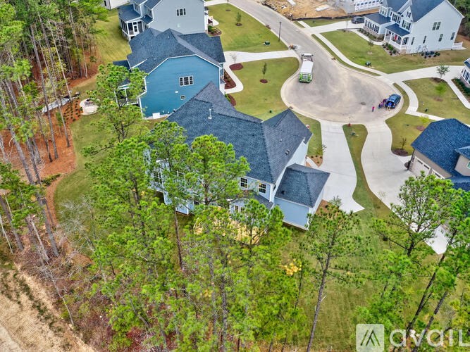 A bird's eye view of a residential area with a swimming pool and a driveway.