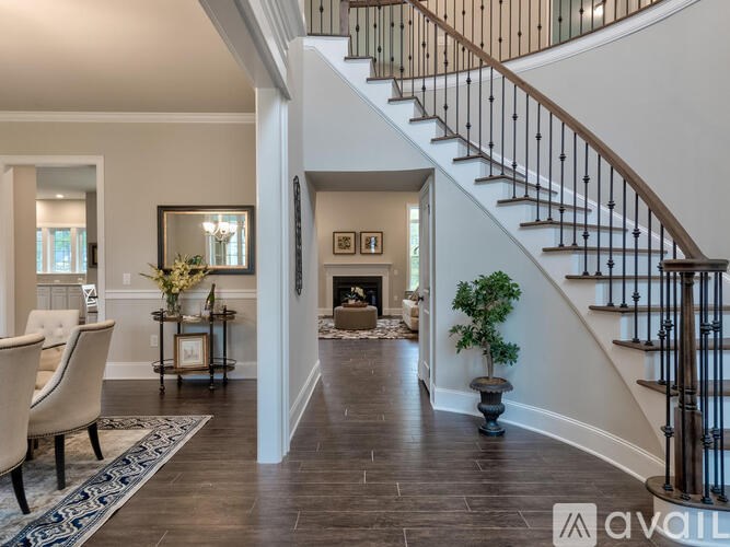 A living room with a staircase and a fireplace.