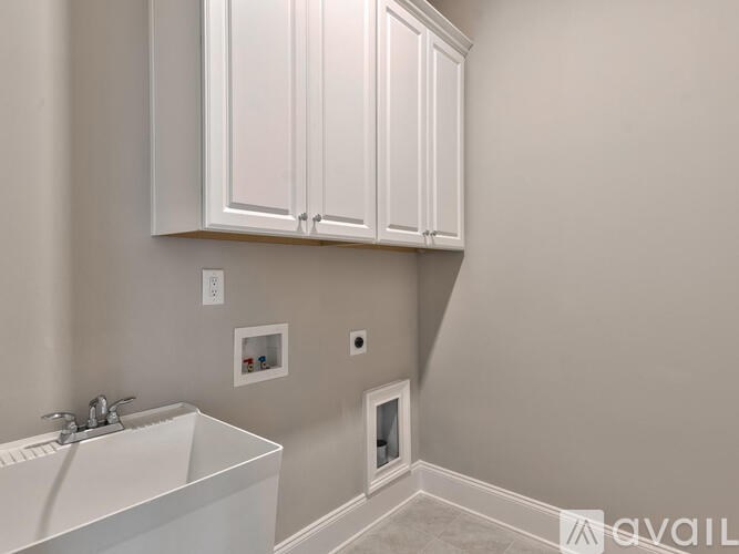 A bathroom with a white sink and cabinets.
