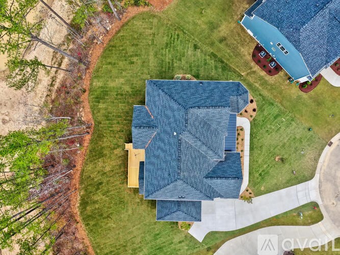 A house with a blue roof is surrounded by a grassy area.