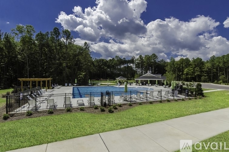 A pool surrounded by a fence and trees.