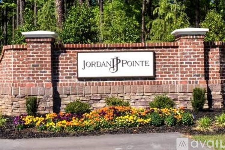 A sign that says Jordan Pointe in front of a brick wall.