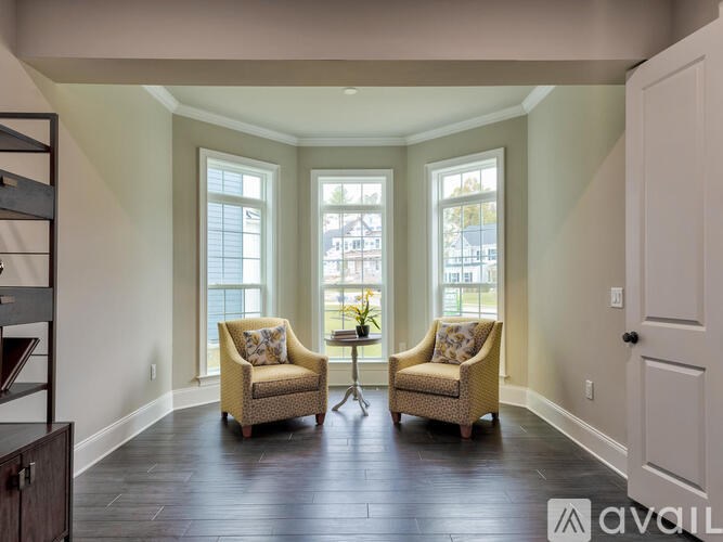 Two chairs are placed in a room with a window.