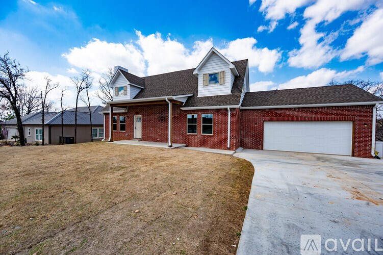 A house with a red brick exterior and a white garage door is available for purchase.