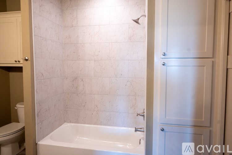 A bathroom with a white tub and a white door.