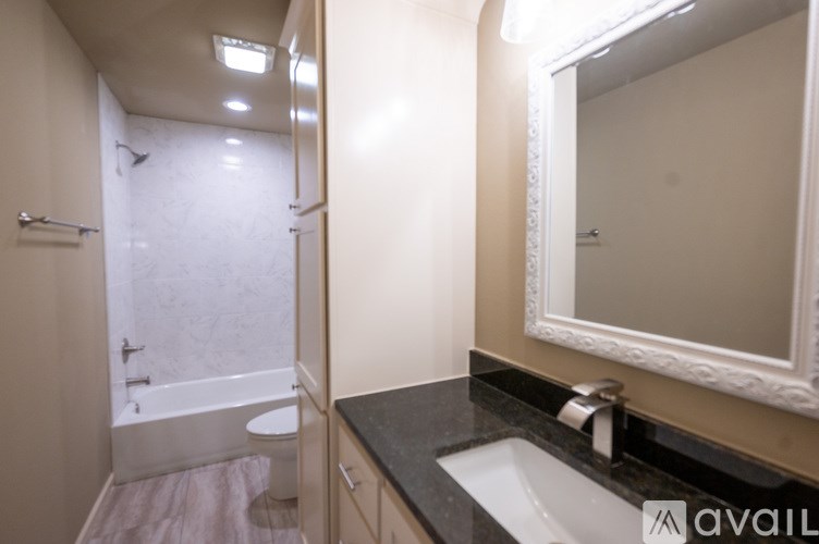 A bathroom with a sink, mirror, and bathtub.