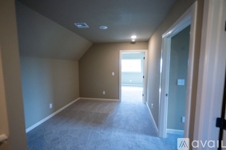 A room with a carpeted floor and a doorway leading to another room.