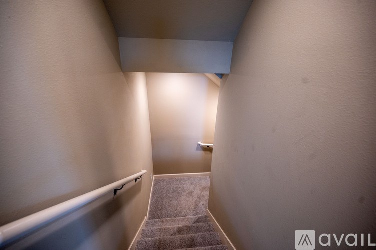 A staircase with a carpeted runner and a metal handrail.