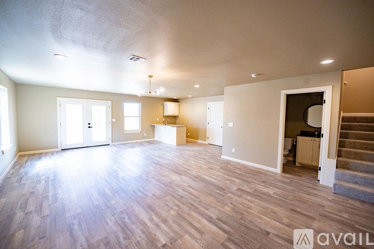 A spacious room with wooden floors and white walls.