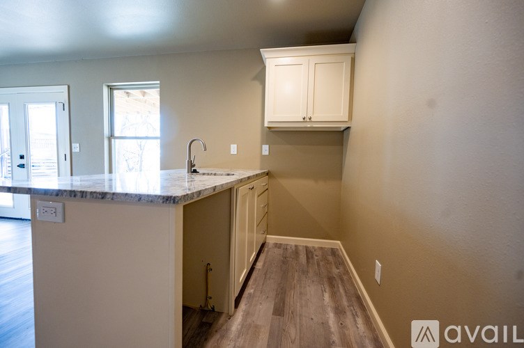 A kitchen with a marble countertop and wooden floors.