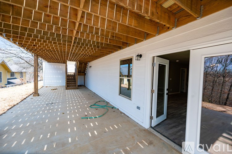 A house under construction with a wooden ceiling and a doorway leading to the outside.