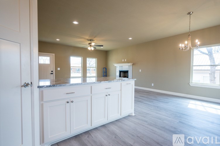 A spacious kitchen with white cabinets and a large island.