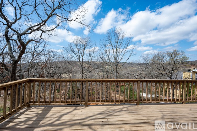 A wooden deck with a railing and a view of a barren landscape.