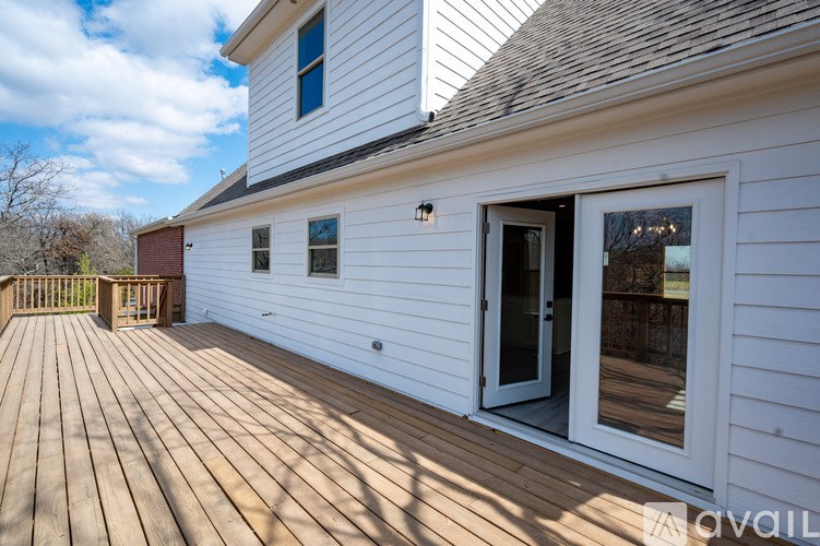 A white house with a deck and a small porch.