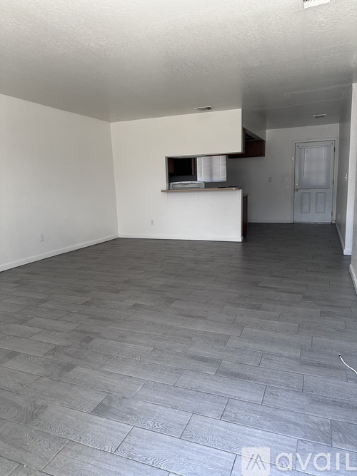 A living room with a grey floor and white walls.