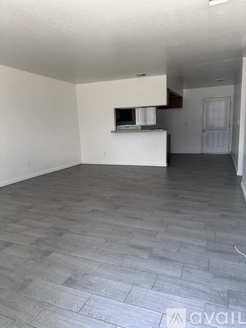 A living room with a grey floor and white walls.