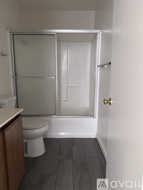 A bathroom with a toilet, sink, and walk-in shower.