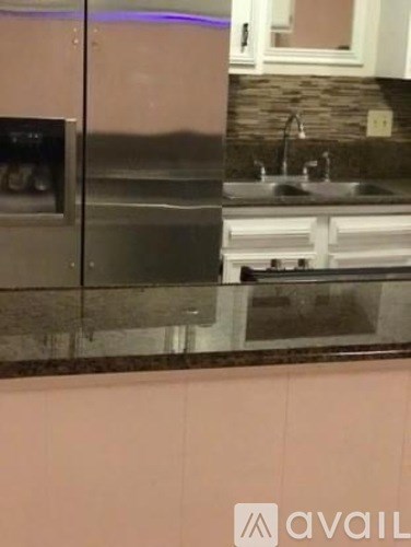 A kitchen with a stainless steel refrigerator and a sink.