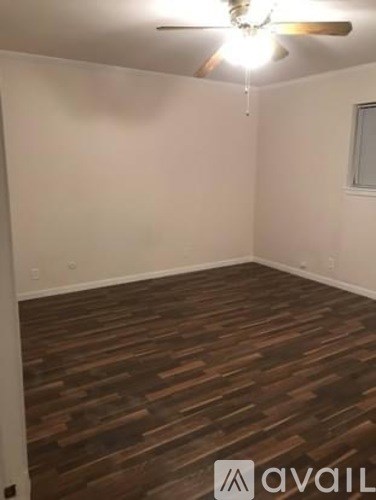 A room with wooden flooring and a ceiling fan.