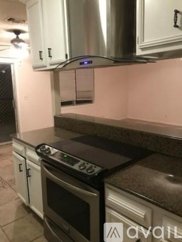 A kitchen with a stove top oven and a range hood.