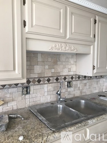 A kitchen under renovation with a sink and cabinets.