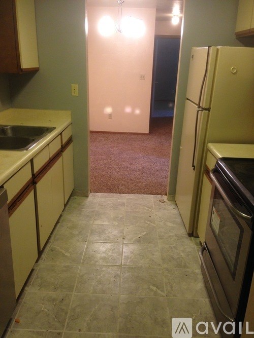 A kitchen with a sink, refrigerator, and oven.