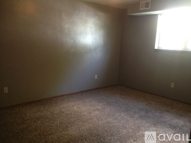 A room with a window and carpeted floor.