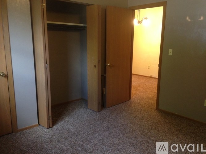 A room with a carpeted floor and a wall-mounted light fixture.